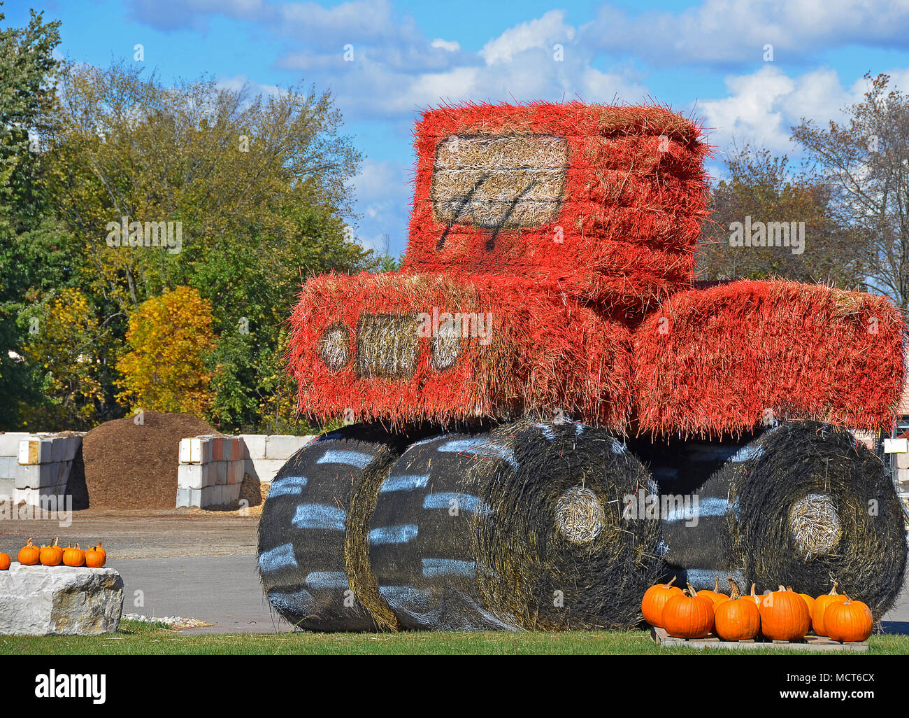 Orange Farm Traktor aus, Spritzlackiert Heuballen Stockfoto