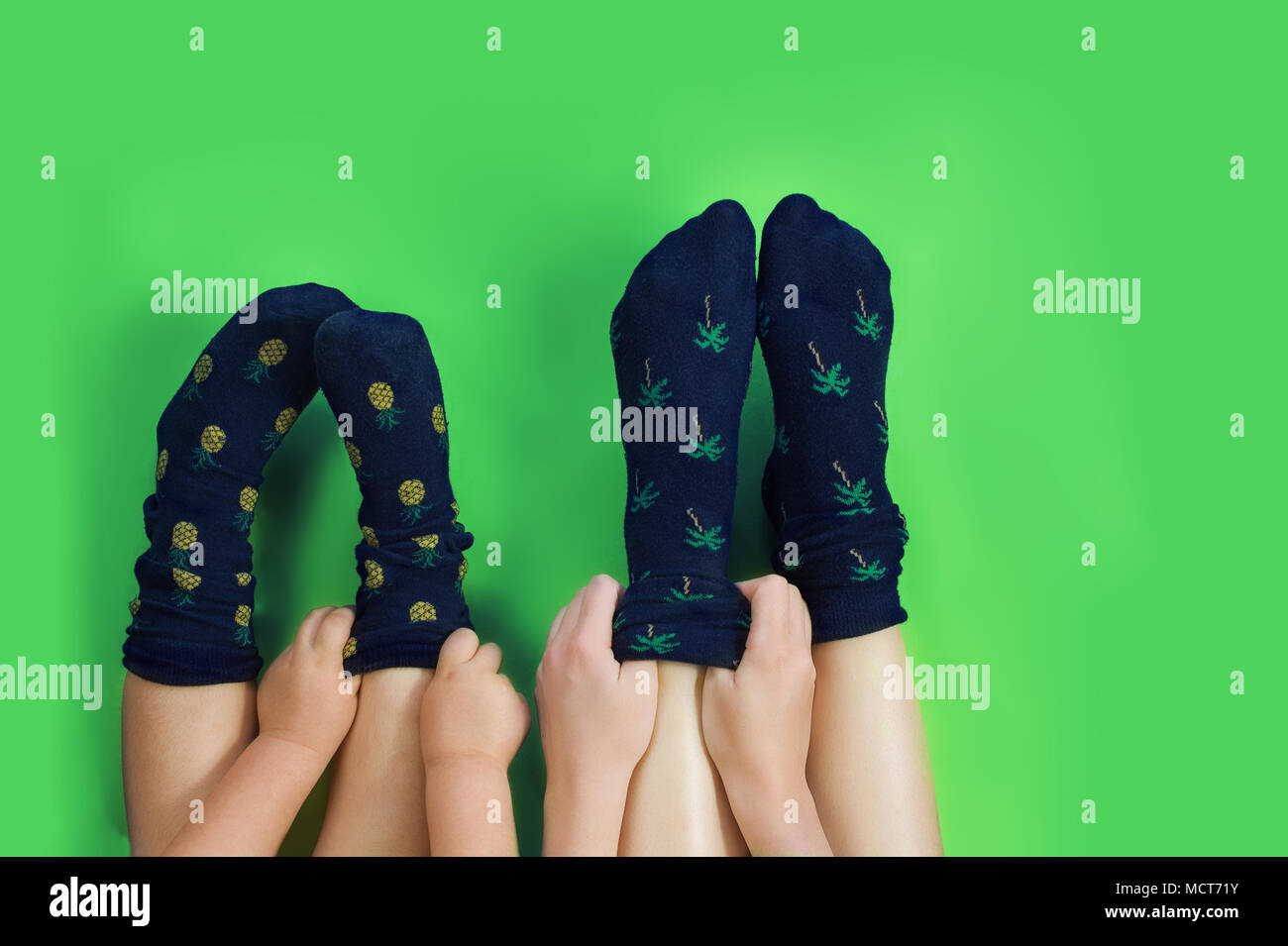 Beine mit niedlichen blauen Socken auf grünem Hintergrund. Stockfoto