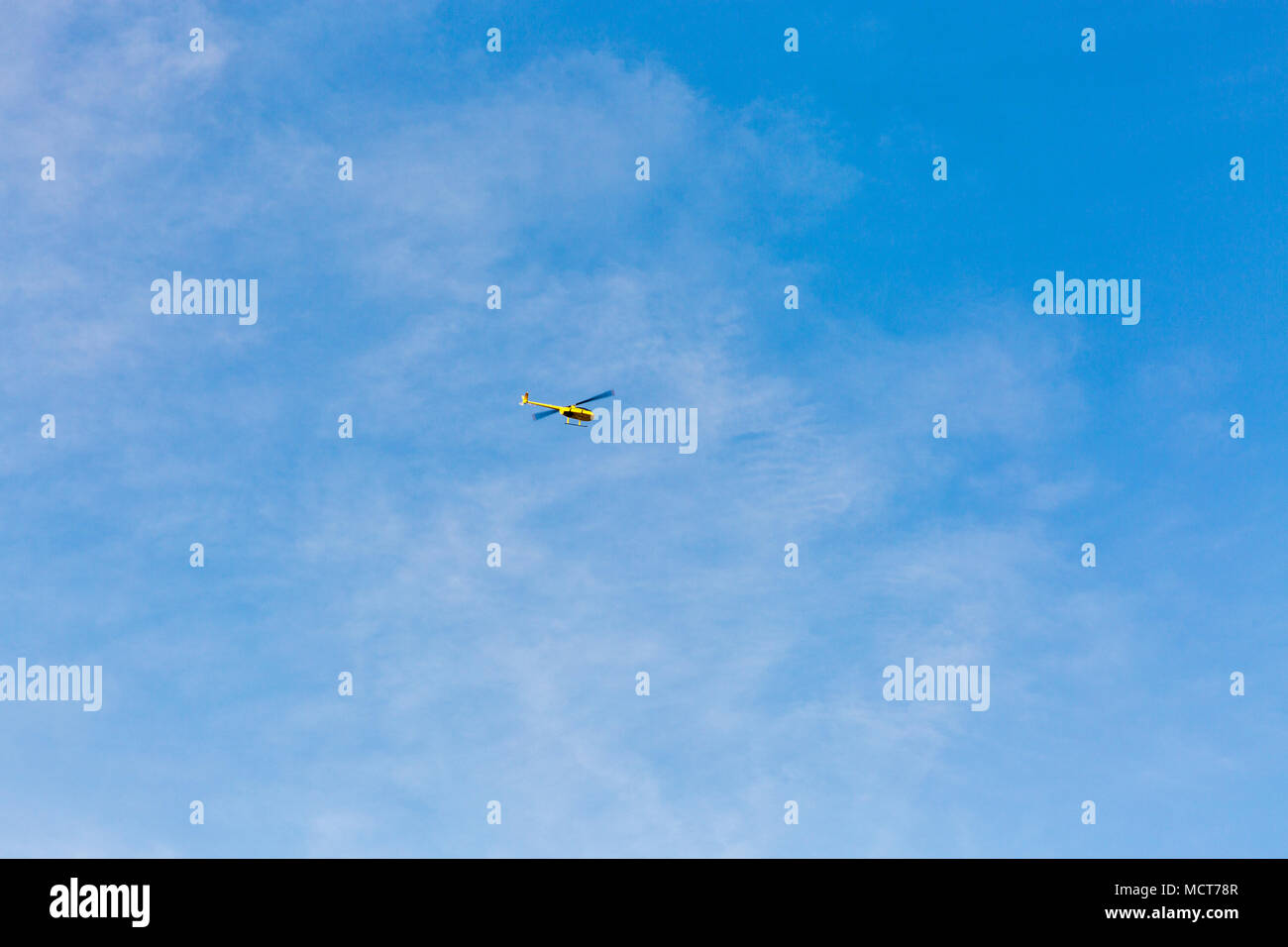 Kleine gelbe Freizeit Hubschrauber fliegen gegen den blauen Himmel. Stockfoto Kleine gelbe Freizeit Hubschrauber fliegen gegen den blauen Himmel. Stockfoto