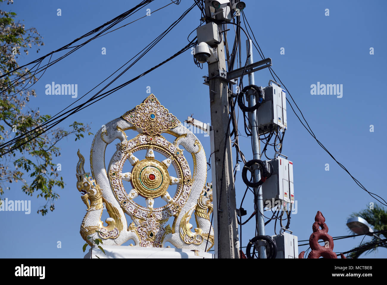 Künstlerische Drachen Wand ornament neben Kabel und Überwachungskameras an Tempel Wat Chedi Luang, Chiang Mai, Thailand Stockfoto