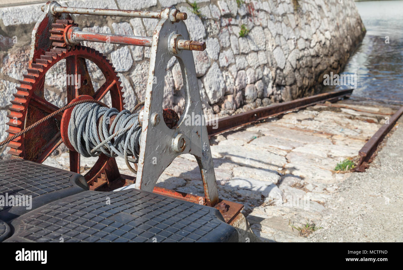 Alte verrostete Winde zum Senken und Heben der Boote im Hafen zu Wasser Stockfoto