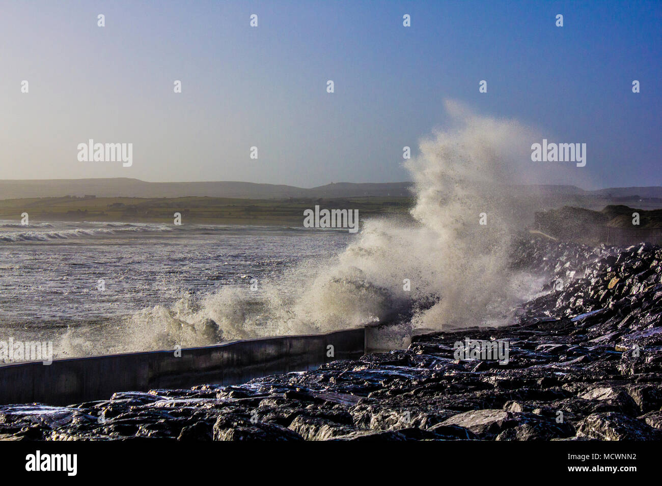Welle in die Wand in Lahinch Strand bei Flut verursachen grosse Splash Stockfoto