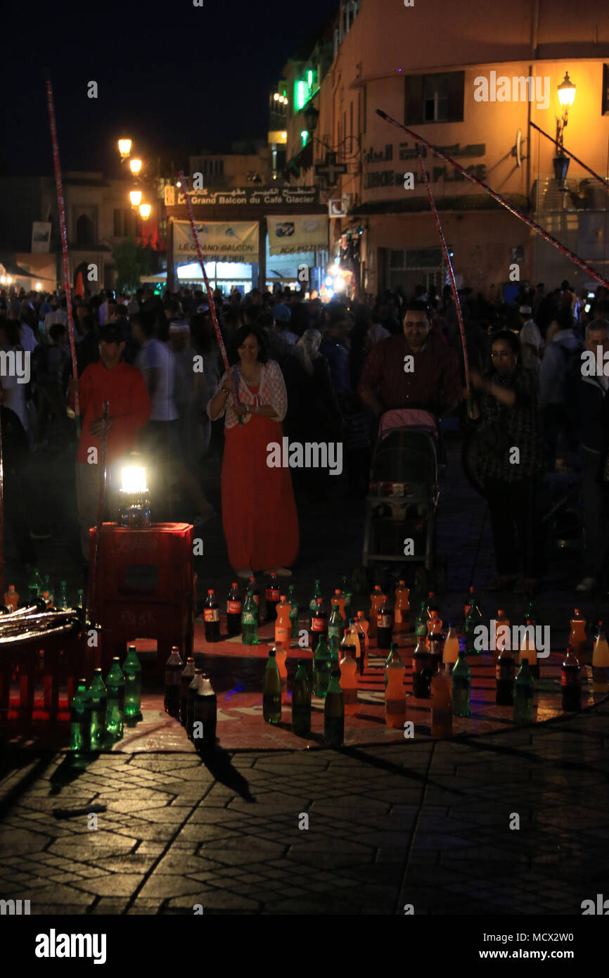 Menschen fischen mit Holzstäbchen für Plastikflaschen auf dem berühmten Platz Djemaa el-Fnaa Platz in Marrakesch, Marokko Stockfoto