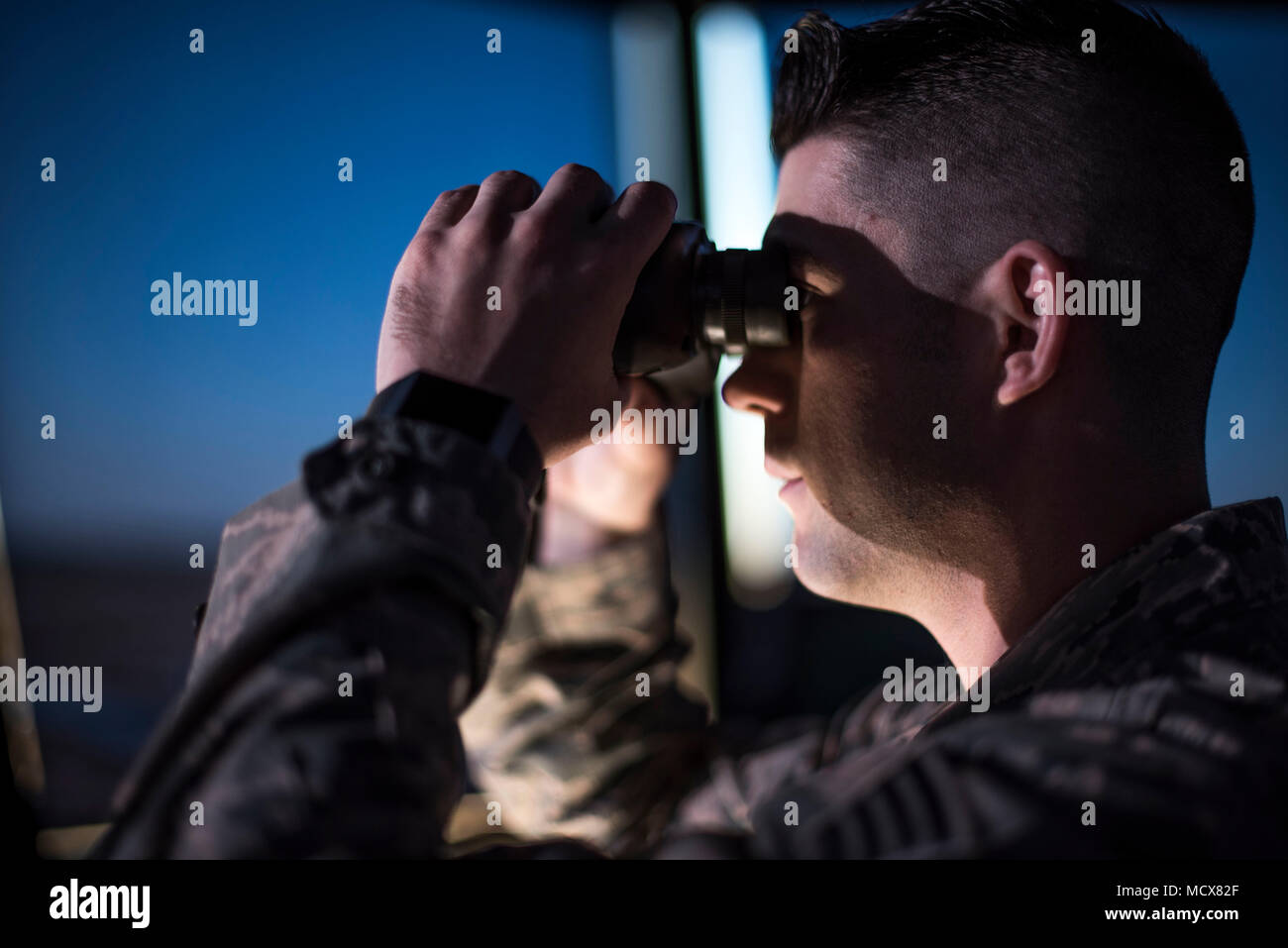 SSgt Chase Kelly, ein Fluglotse, blickt über den Vance Air Force Base flightline mit Fernglas, 1. März 2018. Air Traffic Controller verwenden Fernglas als Werkzeug, um Ihnen zu helfen, größere Entfernungen sehen. (U.S. Air Force Foto von Airman Zachary Heilen) Stockfoto