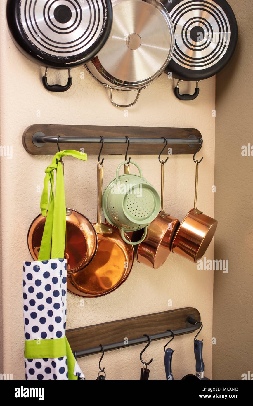 Töpfe und Pfannen hängen an einer Küche Wand, um Platz zu sparen  Stockfotografie - Alamy