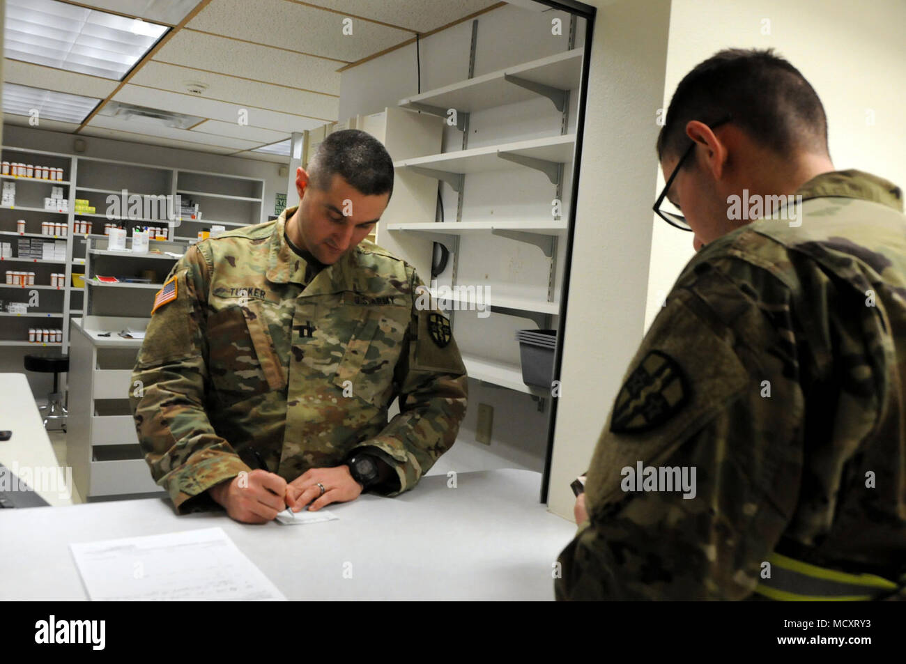 Spc. Jesse White, einem Fachmann in der 7409Th Truppe Medizinische Klinik zugeordnet, demonstriert den Prozess ein Soldat wird durch beim Besuch der TMC gehen. Weiß visits Kapitän Jeremy Tucker, der Apotheke Einsatzleiter, zu simulieren, die eine Verschreibung gefüllt. ARMEDCOM Soldaten zu 7212Th medizinische Unterstützung und 7409Th Truppe Medizinische Klinik zugeordnet unterstützt medizinische Soldat Bereitschaft Verarbeitung und Truppe Medizinische Klinik Operationen während ihrer Ausbildung am Fort McCoy, Wisconsin am März 1-15, 2018. Die erfolgreiche "Proof-of-Concept"-Programm durchgeführt wird, auf die mehrere Armee Rese Stockfoto