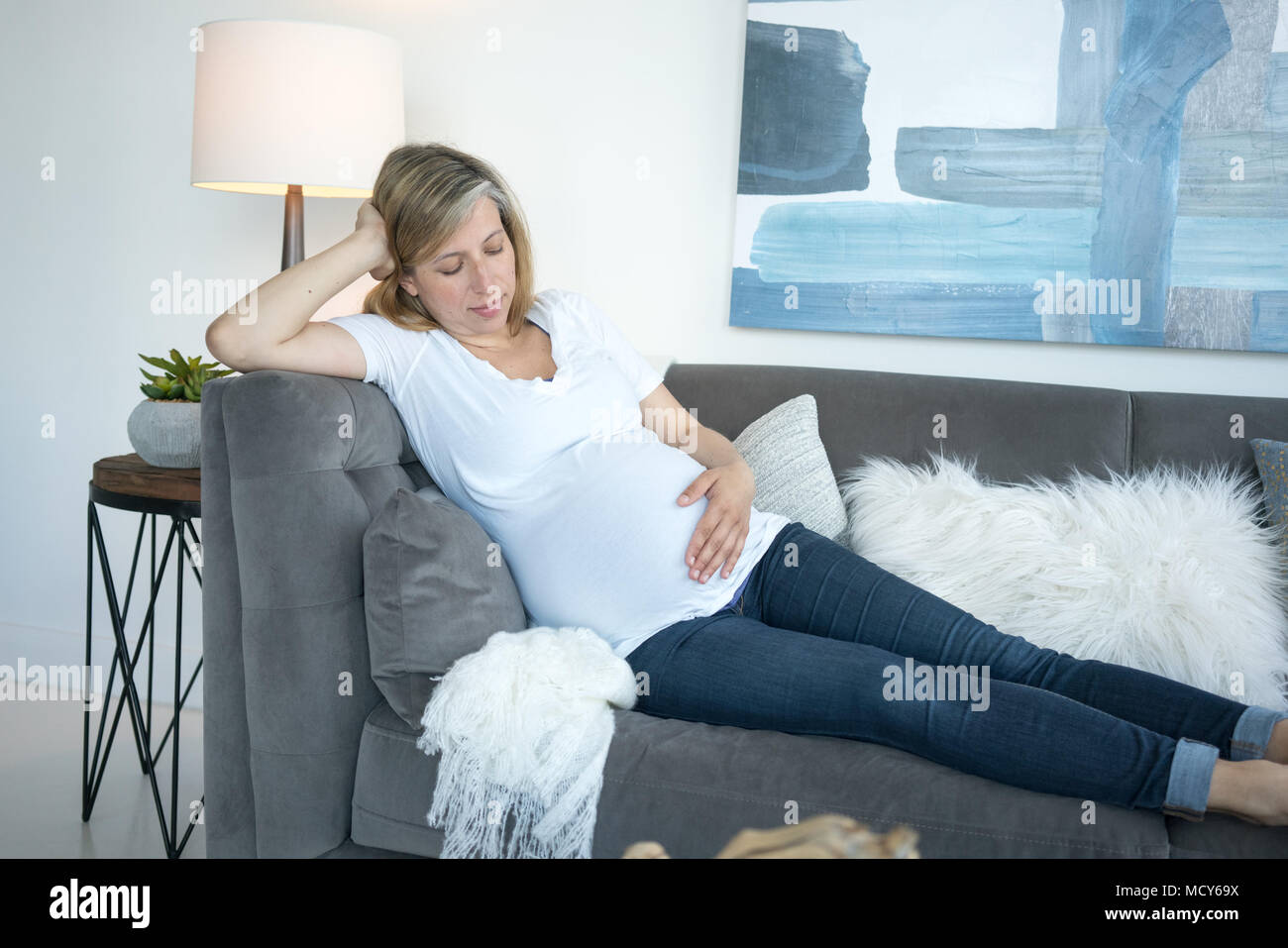 Liegende Frau auf Sofa und berühren ihre schwangeren Bauch Stockfoto