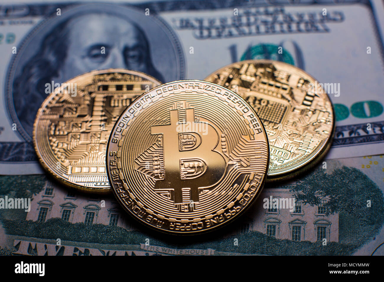 Bitcoin. Gold Bitcoins auf einem hundert Dollar bill Nahaufnahme Stockfoto