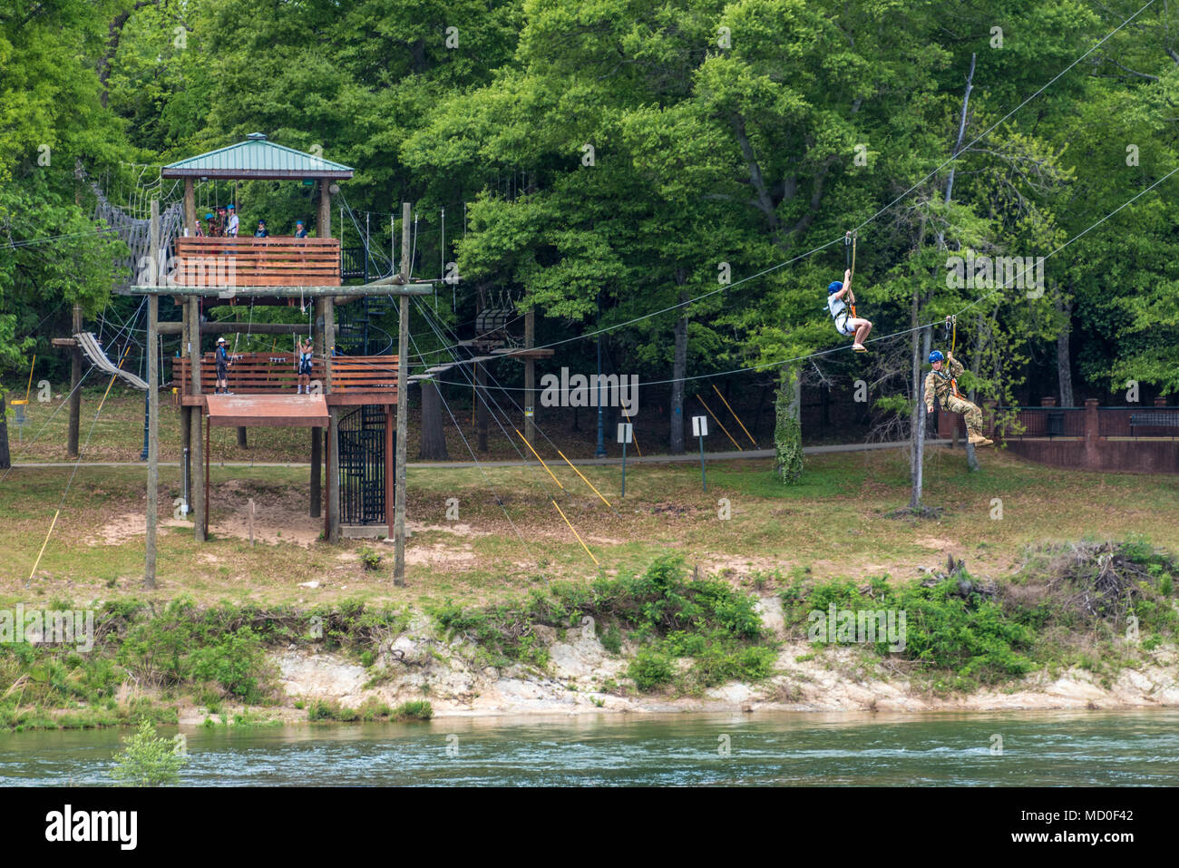 Zipliners genießen Sie eine spannende Fahrt durch den Chattahoochee River von der Baumkrone Turm in Columbus, GA zum Ufer Turm in Phenix City, AL. Stockfoto