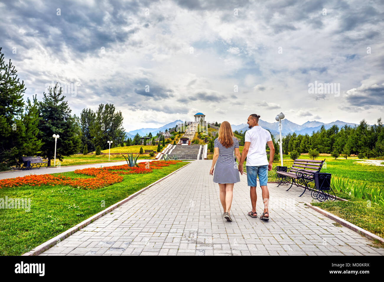 Glückliches Paar in der Holding durch die Hände und ein Spaziergang entlang der berühmten Park in Almaty, Kasachstan Stockfoto
