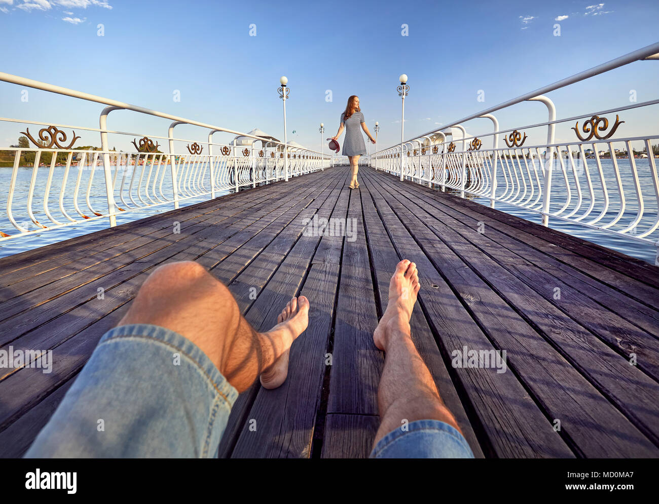 Frau im gestreiften Kleid mit Red Hat zu seinem Freund, auf der Seebrücke am Strand Stockfoto