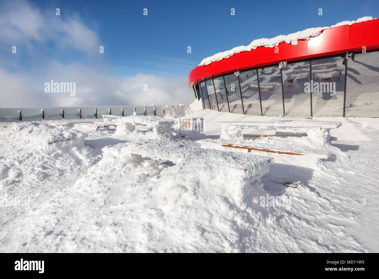 Restaurant Terrasse im Winter. Starker Schneefall verursacht Holzbänken und Tischen sind kaum unter Schneelast sichtbar. Stockfoto