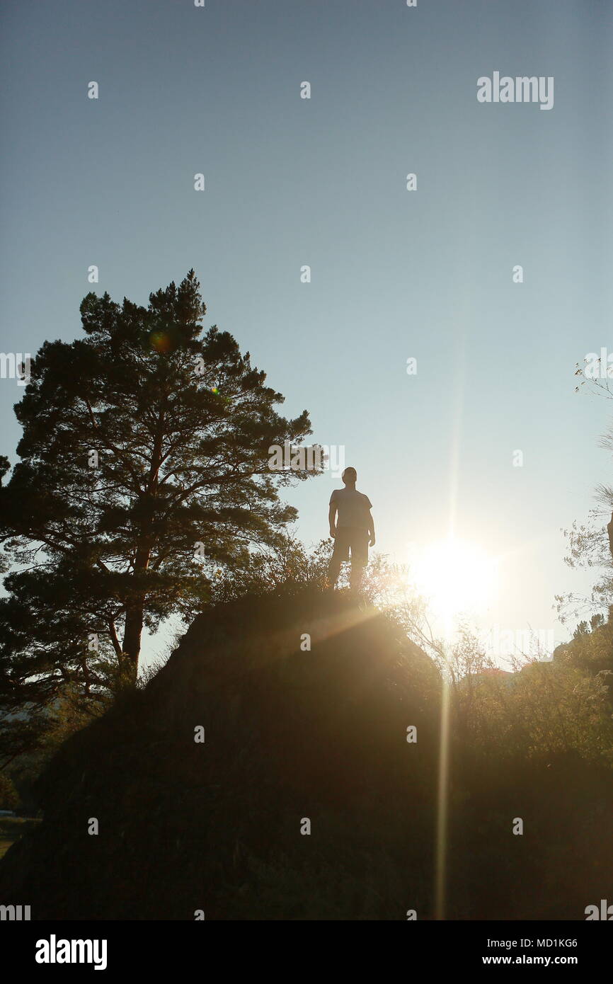 Sommer Silhouette eines Mannes auf einem Berg, oben angekommen, überwand er sich, Sonneneinstrahlung von hinten, freier Platz für eine Unterschrift. Leistung, Ove Stockfoto