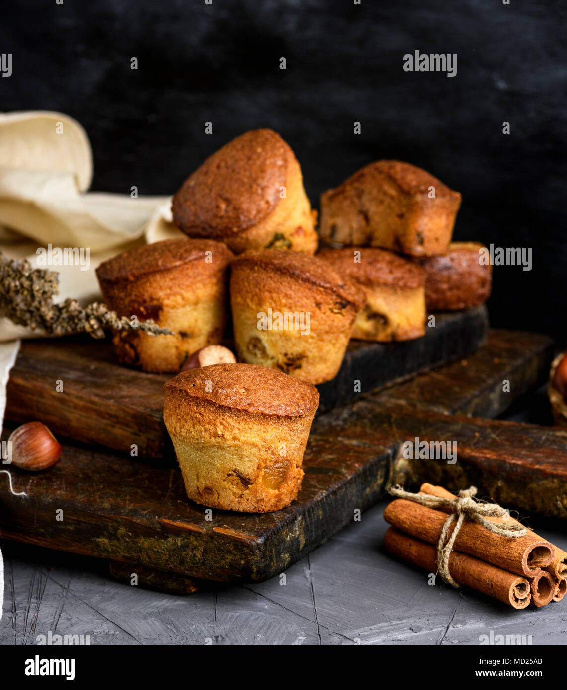 Runde gebackenen Muffins mit trockenen Früchten und Trauben auf einem braunen Holzplatte, schwarz Tisch Stockfoto