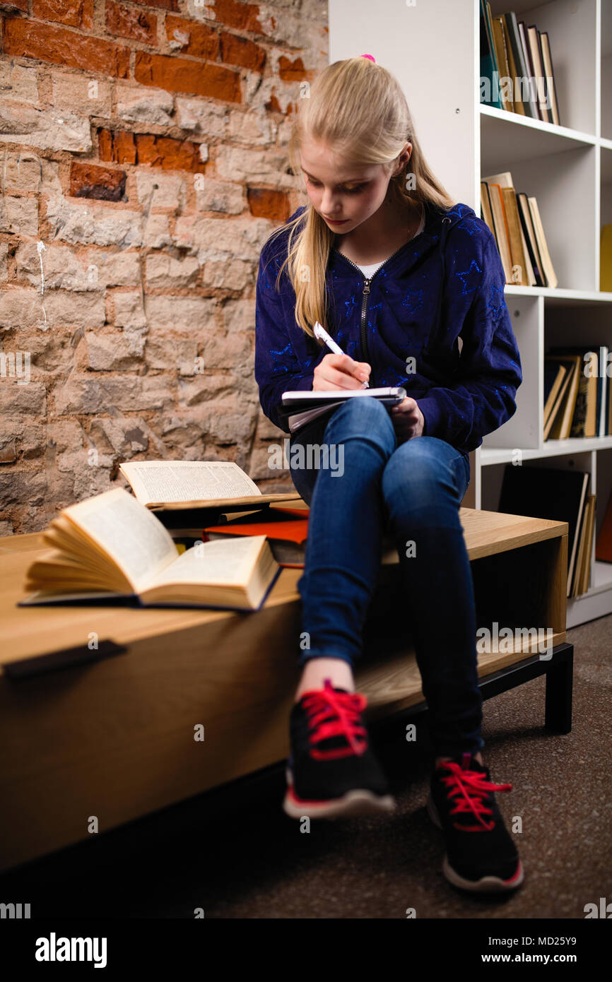 Junges Mädchen in einer Bibliothek Stockfoto