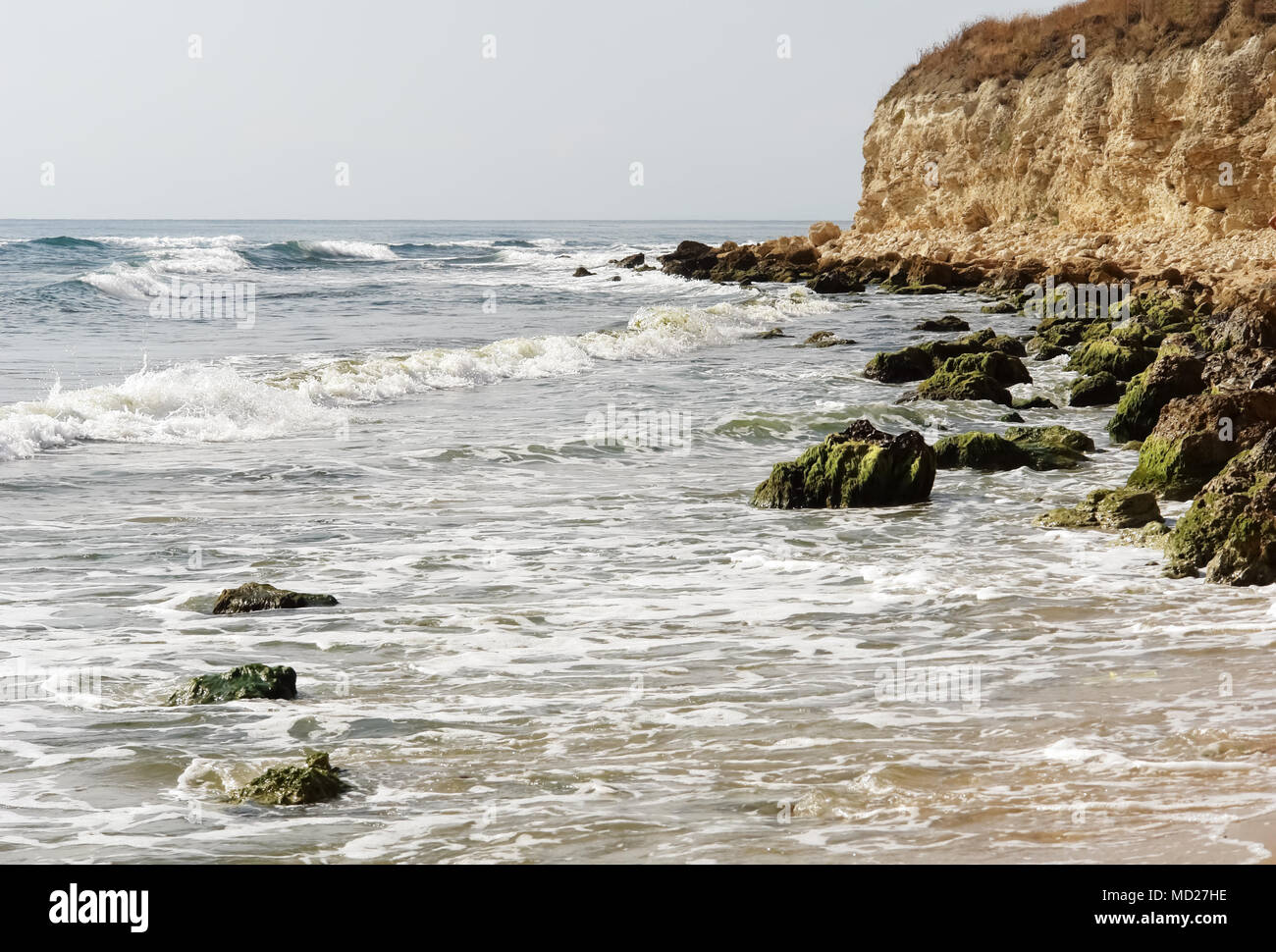 Eine malerische Landschaft mit Wellen, Steine mit grünen Algen und eine hohe, steile Ufer an der Küste des Schwarzen Meeres. Stockfoto