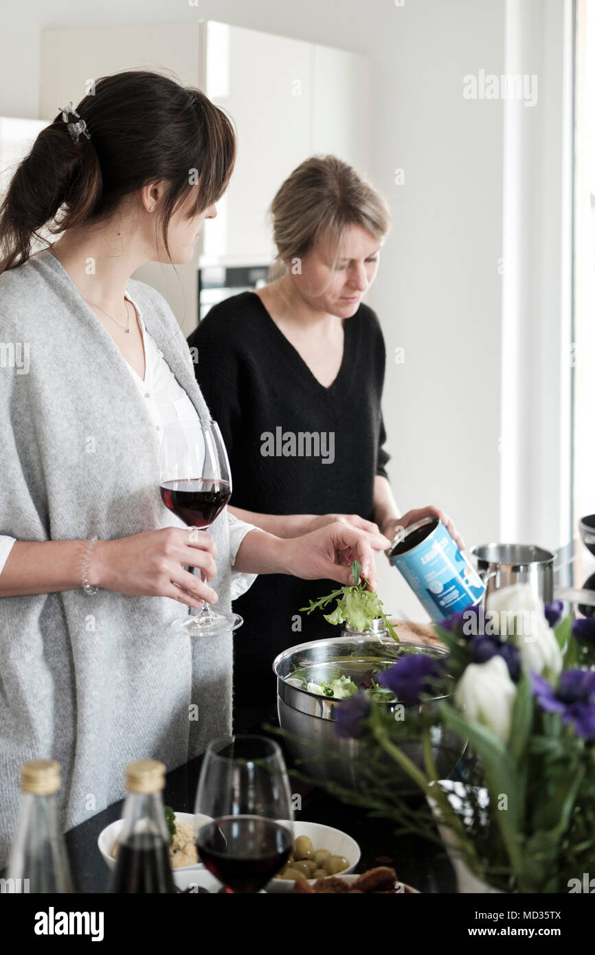 Gruppe von Freunden beiläufig Snacking auf eine Auswahl von Lebensmitteln beim Lachen und sich zu amüsieren. Stockfoto