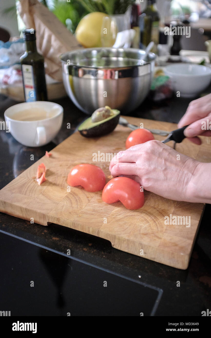 Kochen zu Hause. Person Zerkleinern von frischen Tomaten. Stockfoto