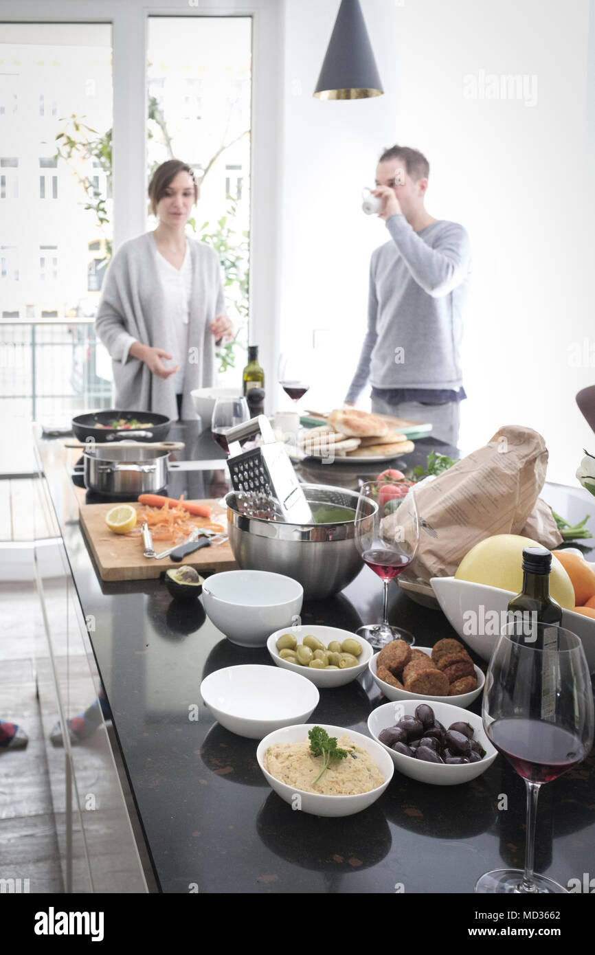 Selectiive Fokus - vegetarische Dips auf dem Tisch. Gruppe von Freunden sind, die zusammen kochen, beiläufig Snacking auf eine Auswahl von Lebensmitteln beim Lachen Stockfoto
