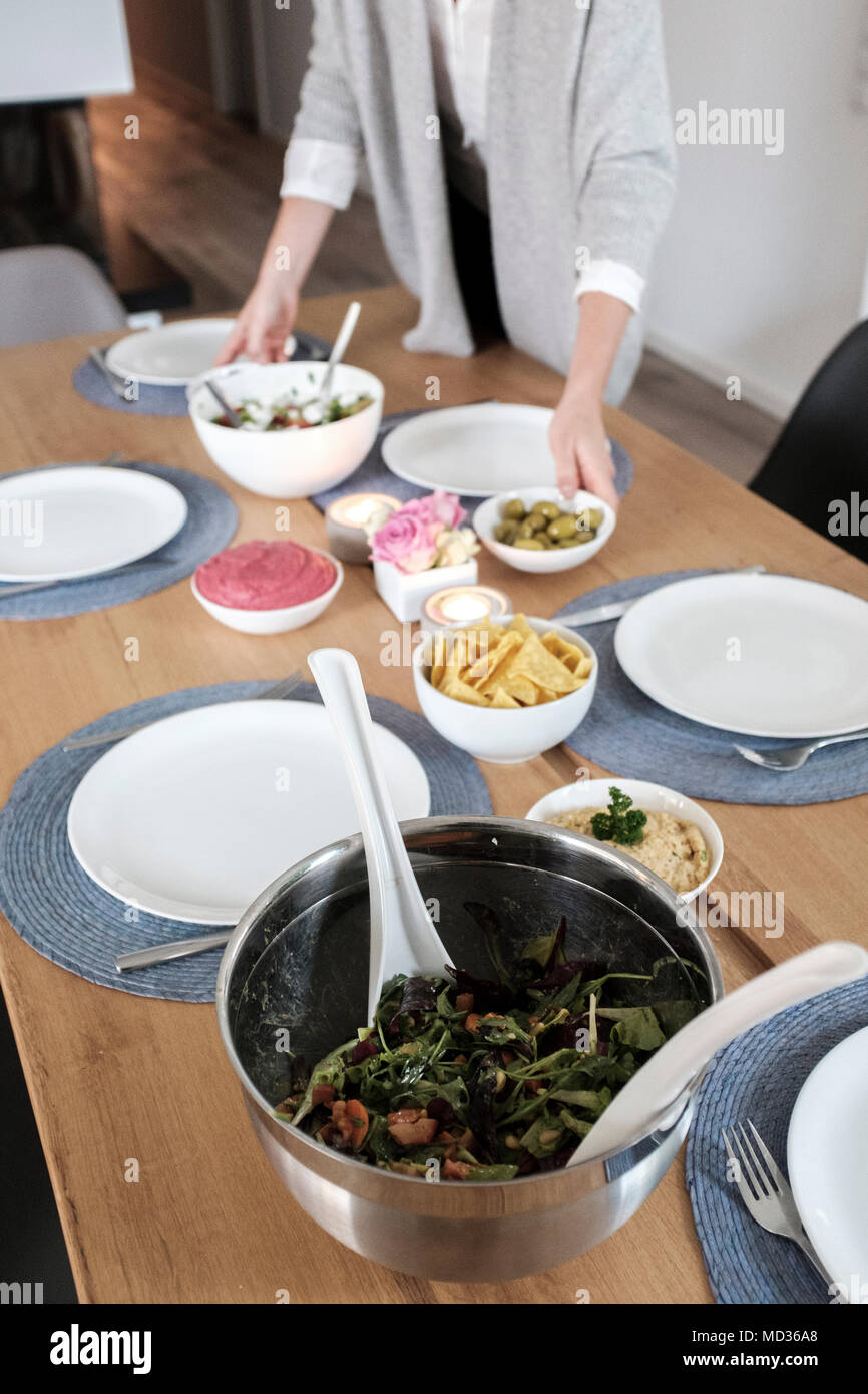 Einrichten der Tabelle für vegtarian Mahlzeit - griechischer Salat, gemischter Salat, grüne Oliven und Rote Beete hummus Stockfoto