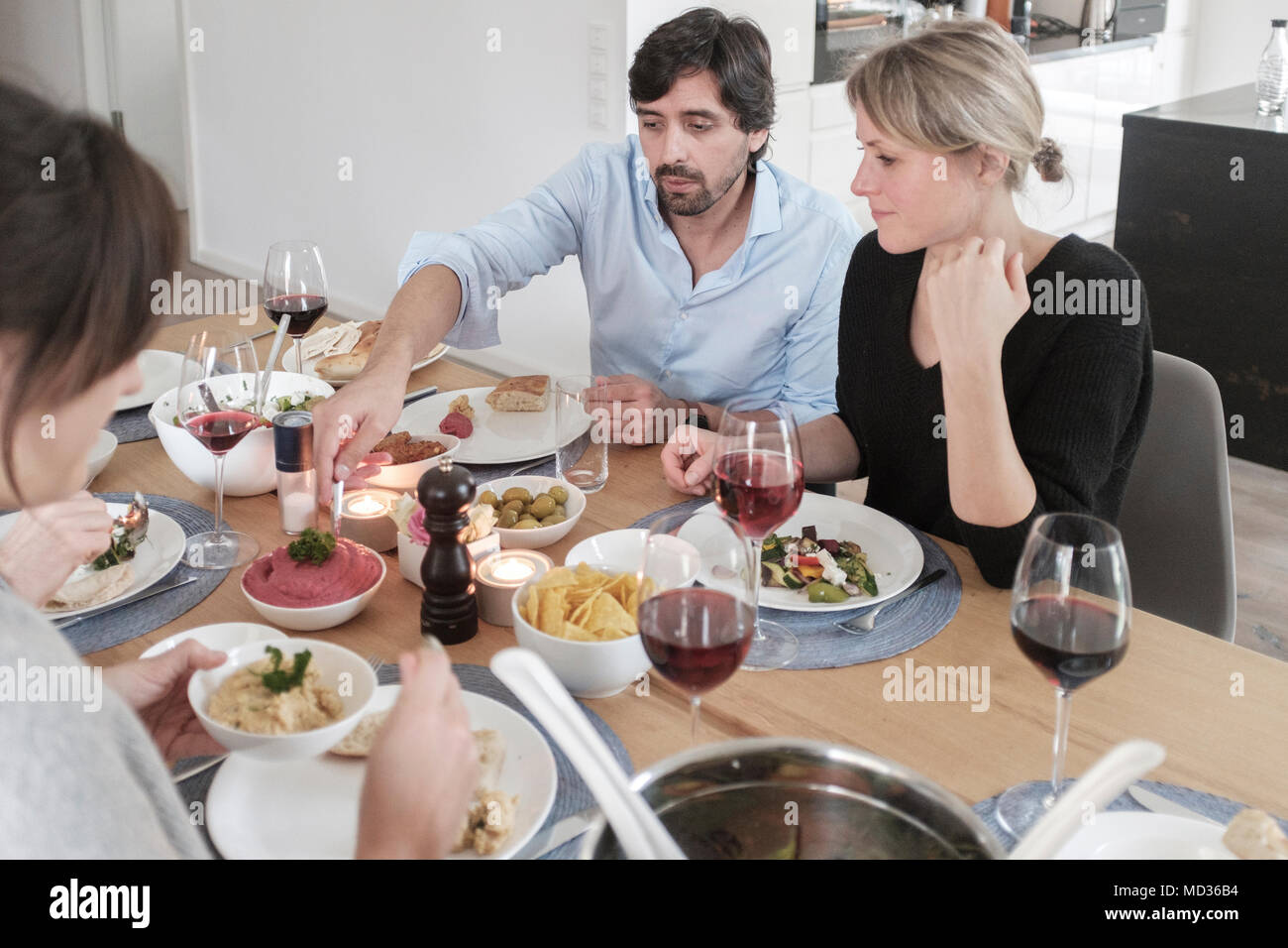 Vegetarisches Mittagessen. Gruppe von Freunden beiläufig Snacking auf eine Auswahl von Lebensmitteln beim Lachen und sich zu amüsieren. Stockfoto