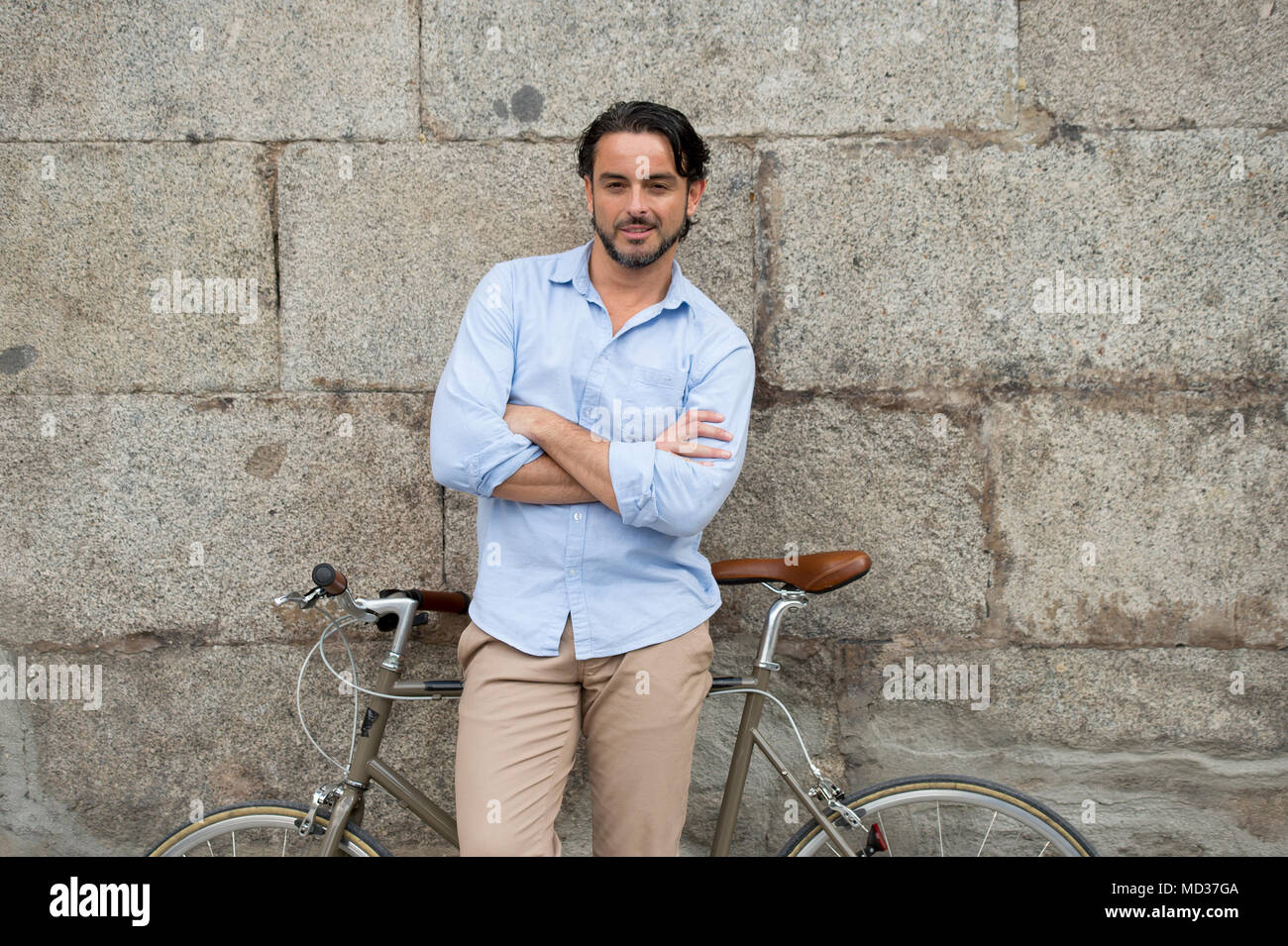 Junge glücklich attraktive latin Mann in casual trendy Kleidung lächelt fröhlich Reiten auf vintage Coole Retro Fahrrad in moderner, stilvoller Lifestyle urban Styl Stockfoto