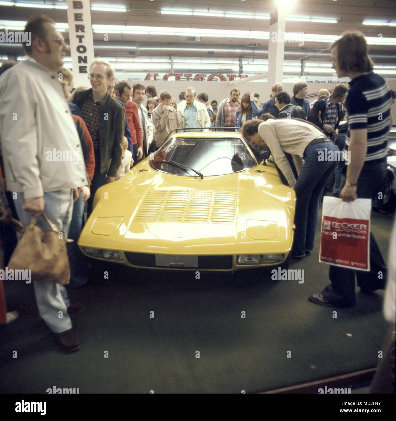 Besucher bewundern die gelben Körper eines Sportwagen des italienischen Unternehmens Bertone, auf der Internationalen Automobilausstellung IAA in Frankfurt am Main 1977. Foto: Albert Riethausen (c) dpa-Bericht | Verwendung weltweit Stockfoto