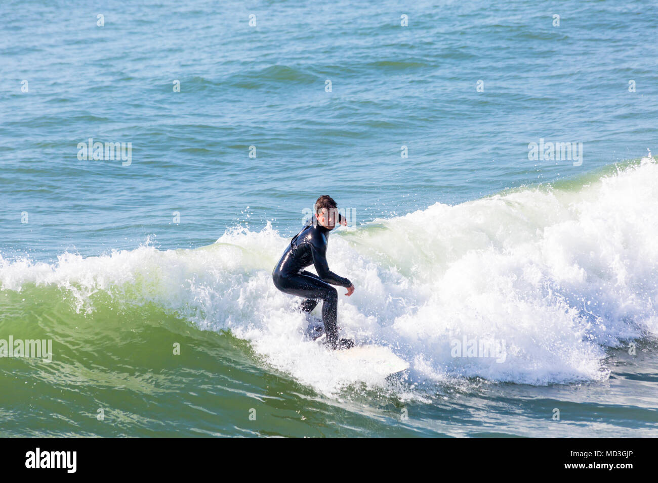 Bournemouth, Dorset, Großbritannien. 18. April 2018. UK Wetter: große Wellen bieten ideale Surfbedingungen am Strand von Bournemouth am heißesten Tag des Jahres so weit. In Aktion auf Surf Board einer Welle Surfer. Stockfoto