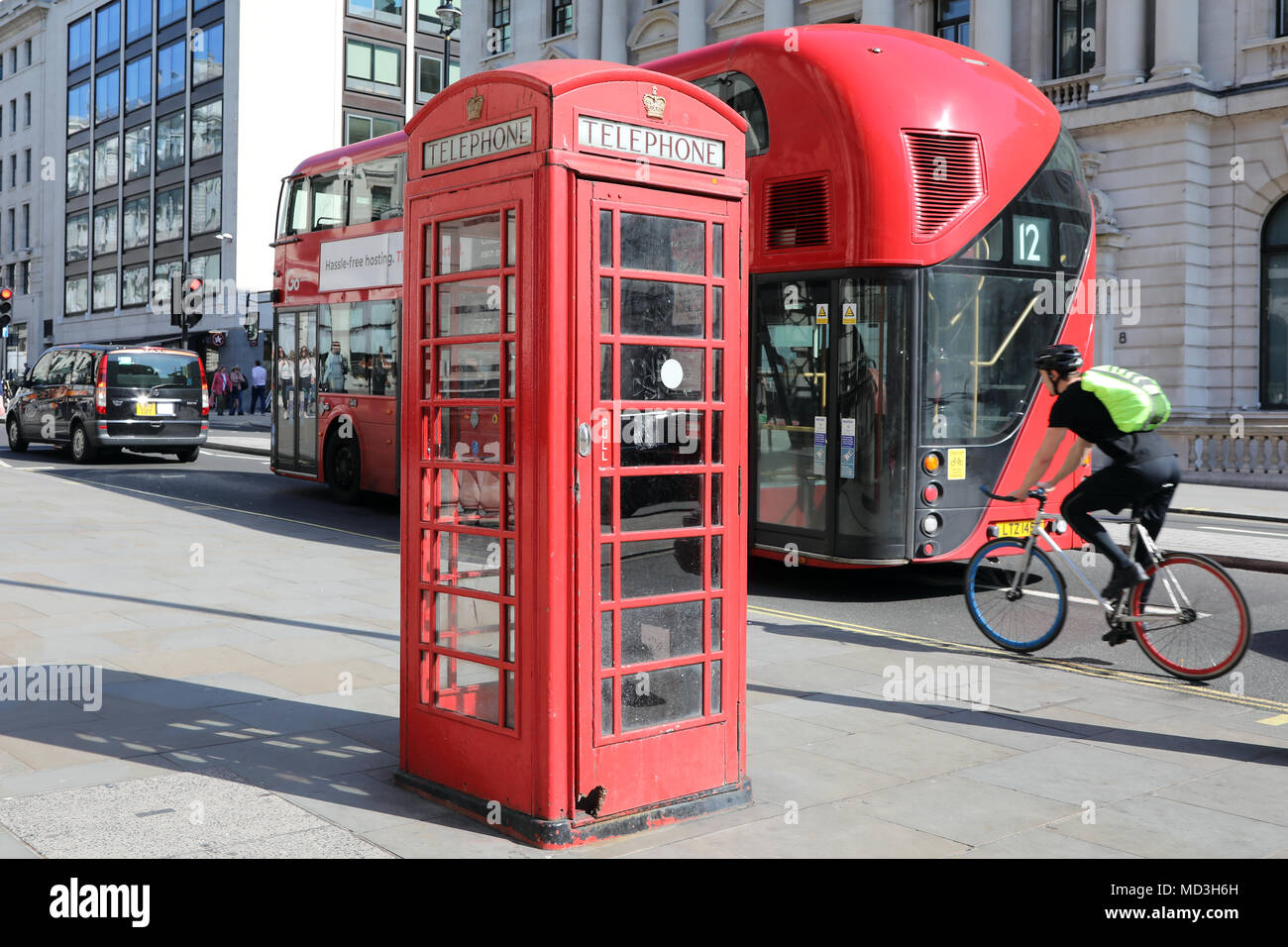 London, Großbritannien. 18. April 2018. Eine rote Telefonzelle am Waterloo Place, London, mit einem traditionellen roten London Bus und ein Radfahrer vorbei, am 18. April, 2018 Quelle: Dominic Dudley/Alamy leben Nachrichten Stockfoto