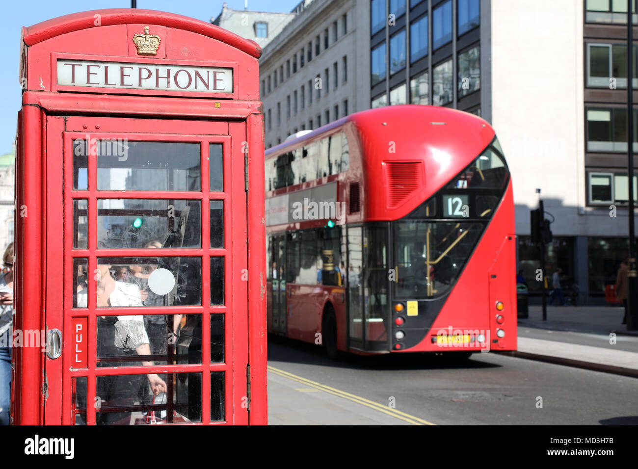 London, Großbritannien. 18. April 2018. Eine rote Telefonzelle am Waterloo Place, London, mit einem traditionellen roten London Bus vorbeifahren, am 18 April, 2018 Quelle: Dominic Dudley/Alamy leben Nachrichten Stockfoto