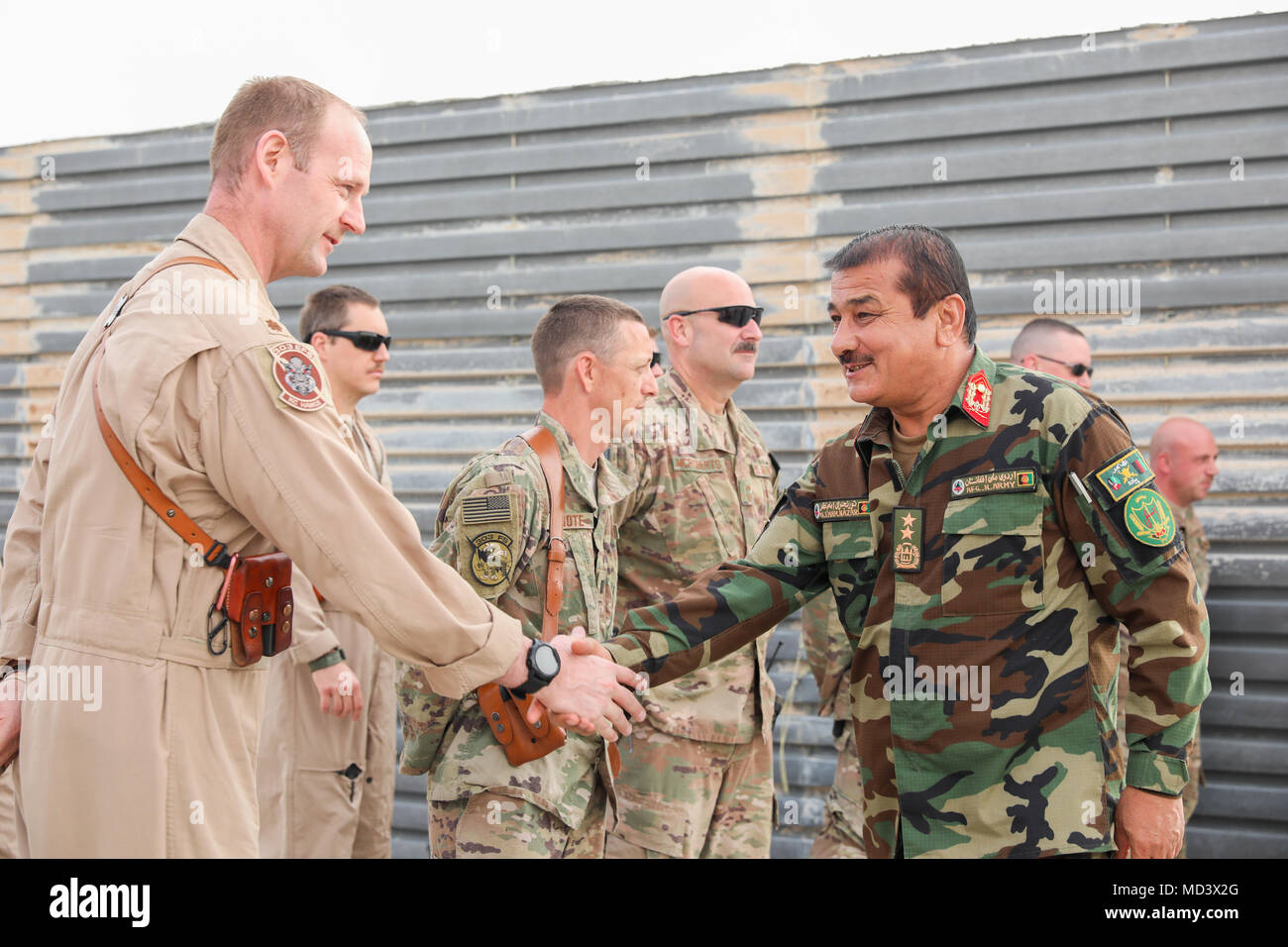 Generalmajor Eman Nazar (rechts), die 205Th Corps Commander für Afghanistan, schüttelt Hände mit einem Pilotprojekt mit 303Rd Expeditionary Fighter Squadron, 451St Air Expeditionary Group, bei einem informellen Anerkennung Zeremonie, 13. März 2018, in Kandahar, Afghanistan. Nazar anerkannten acht Flieger während der Zeremonie für ihre Unterstützung der afghanischen nationalen Armee bei ihrer jüngsten Missionen. (U.S. Armee Foto: Staff Sgt. Neysa Canfield/TAAC-S PAO) Stockfoto