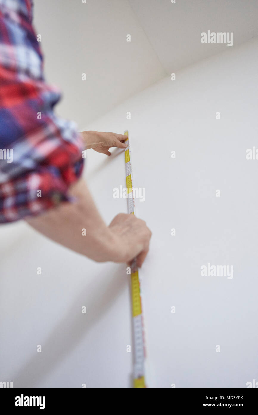 Person messen weiße Wand Stockfoto