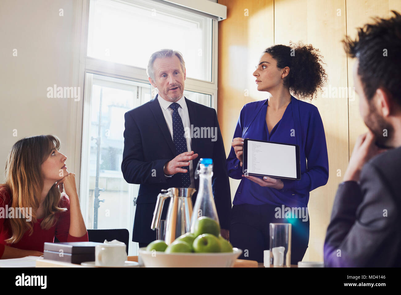 Geschäftsfrau und männlichen Kollegen eine Präsentation halten auf digitalen Tablet während der Konferenz Stockfoto