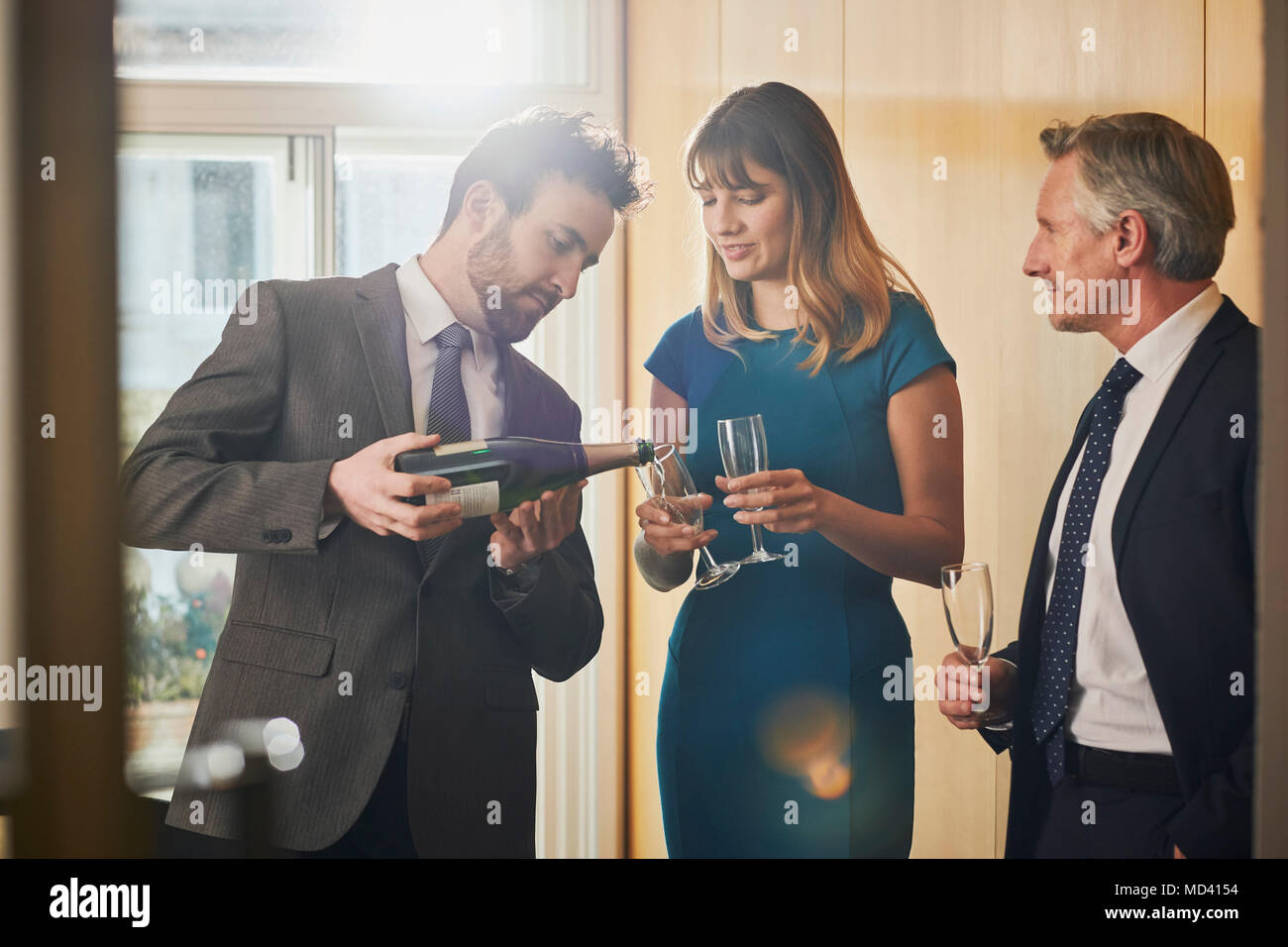 Geschäftsmann gießen Champagner im Büro Feier Stockfoto