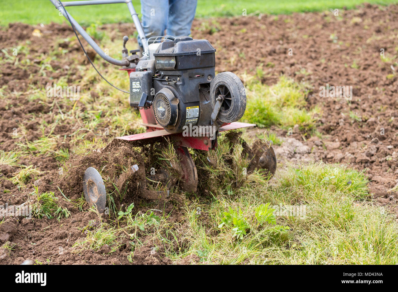 Senior Landwirt Gärtner im Garten arbeitet mit rototiller, Deichsel
