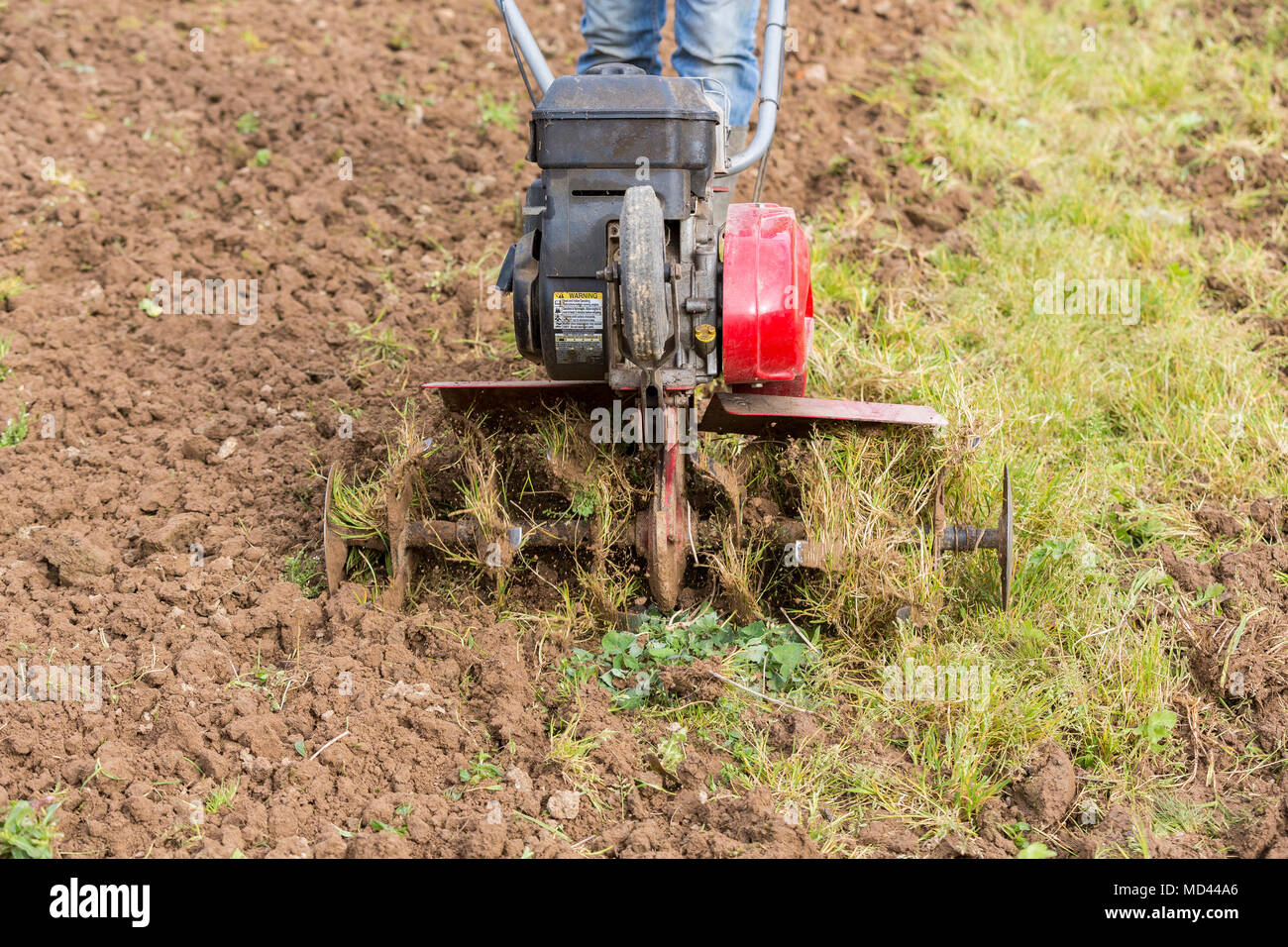 Senior Landwirt Gärtner im Garten arbeitet mit rototiller, Deichsel