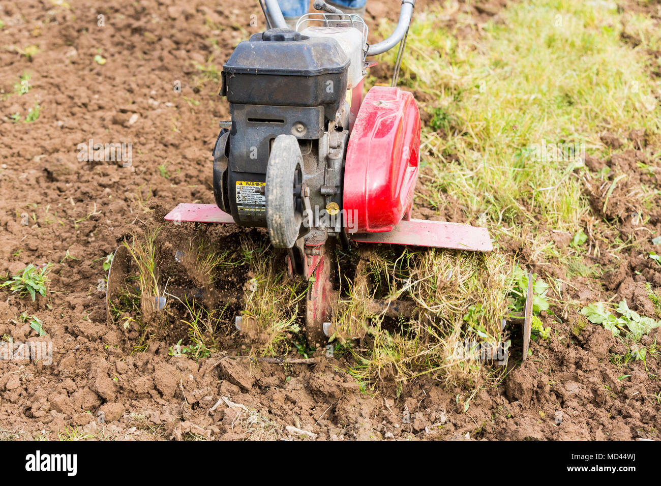 Senior Landwirt Gärtner im Garten arbeitet mit rototiller, Deichsel