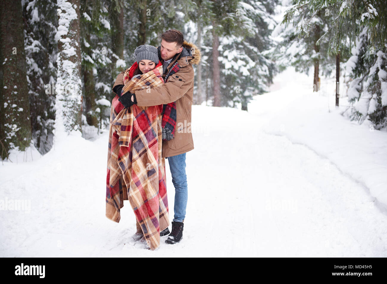 Junges Paar umarmen im Schnee Stockfoto