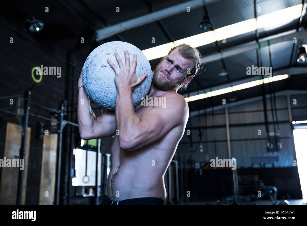 Mann, das trainieren im Fitnessraum, mit Atlas Stein Stockfoto