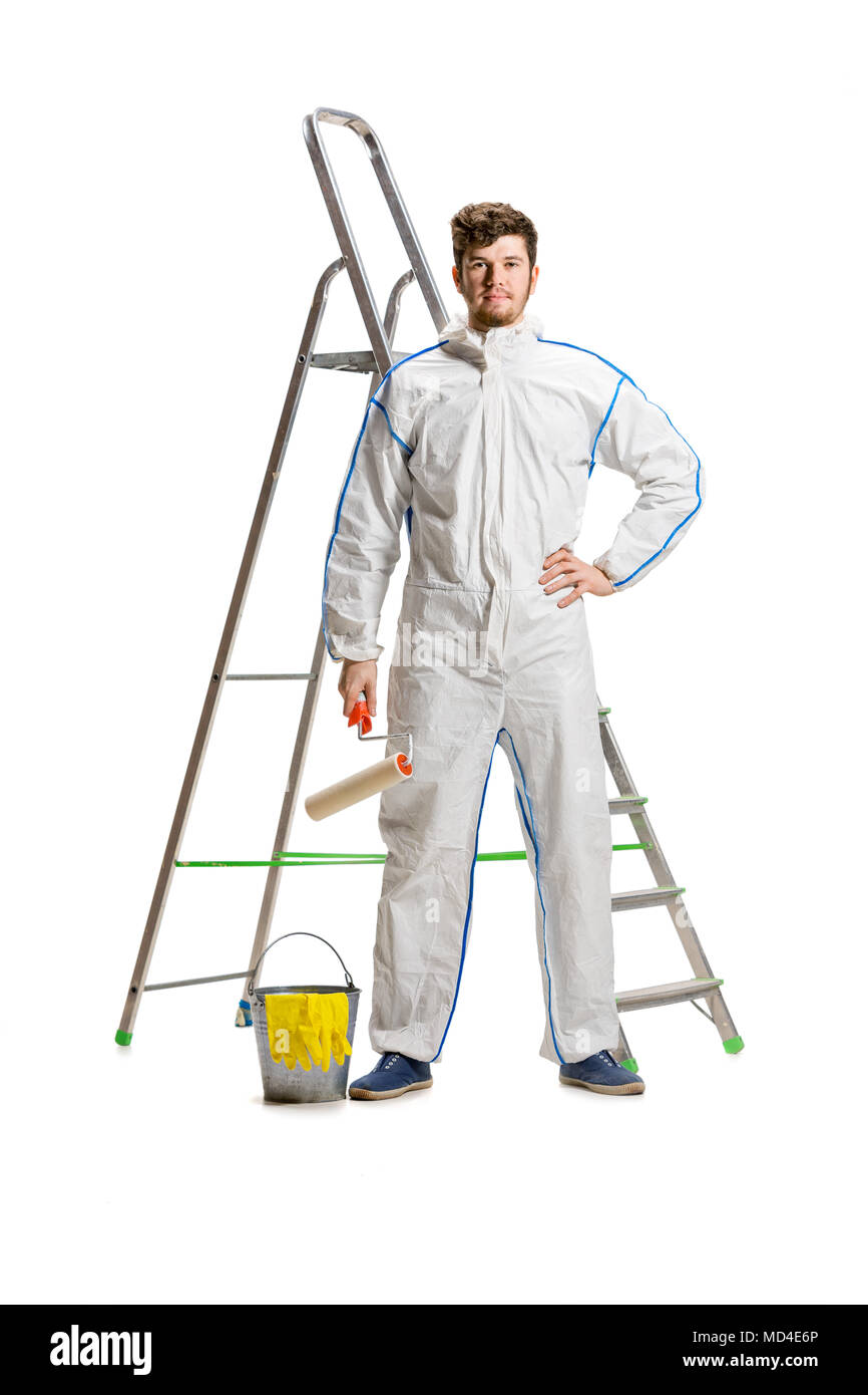 Junge männliche Dekorateur malen mit einem Farbroller kletterte eine Leiter auf weißem Hintergrund. Stockfoto