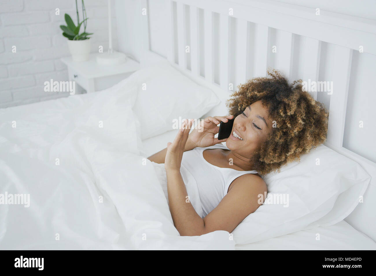 Inhalt Frau am Telefon sprechen im Bett Stockfoto