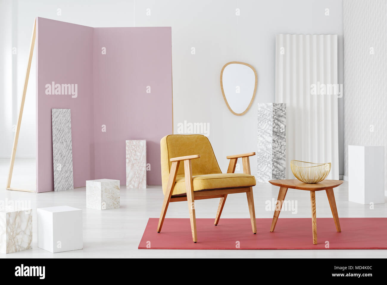 Marmor, Würfel und Dekorationen in einem weißen, eleganten Interieur mit stilvollen gelb und Holzmöbeln Ausstellung und ein Pastell rosa Trennwand Stockfoto