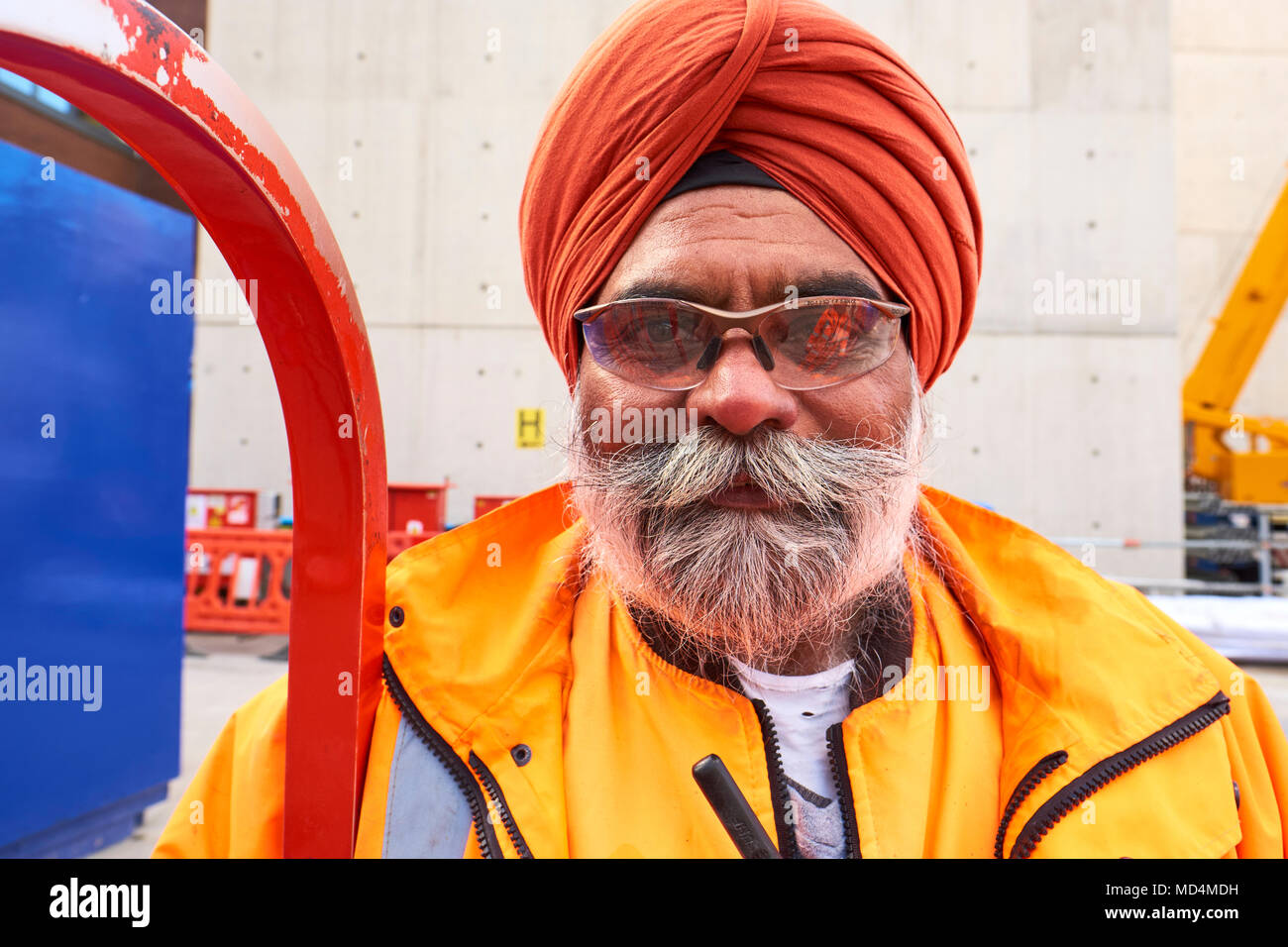 Ein Sikh Crossrail Arbeiter mit harten Hut Freistellung in hohe Sichtbarkeit Arbeit tragen vor Ort im Zentrum von London. Stockfoto