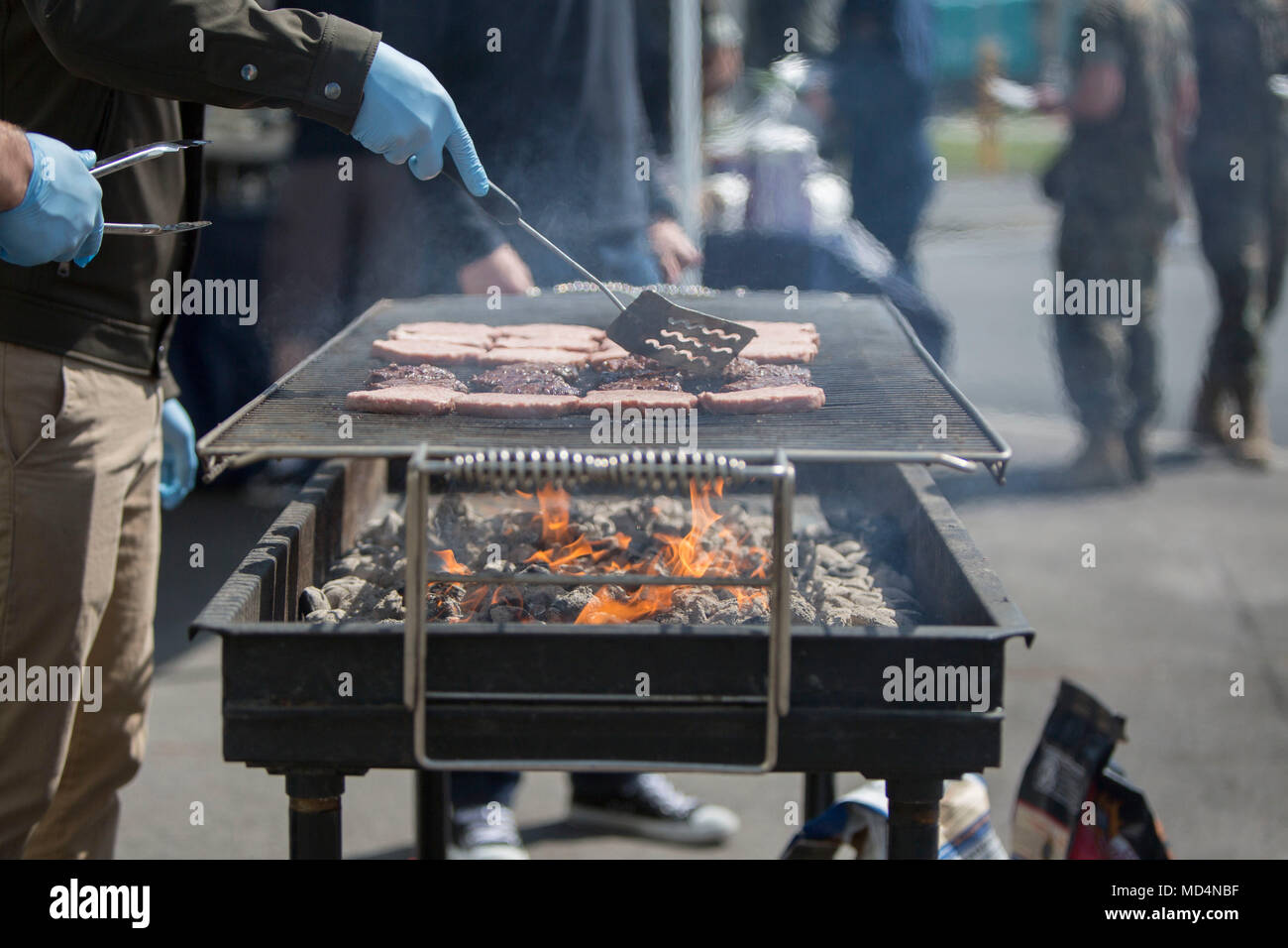 United Service Organizations ist eine gemeinnützige Organisation, die 1941 gegründet wurde, um den US-amerikanischen Servicemitarbeitern weltweit Moral und Freizeit zu bieten. Das Archivbild dokumentiert Freiwillige, die während eines Grills der Adoption-A-Unit für die Marine Aerial Refueler Transport Squadron 152 und das Fleet Readiness Center Western Pacific auf der Marine Corps Air Station Iwakuni, Japan, am 23. März 2018 Lebensmittel zubereiten. Stockfoto
