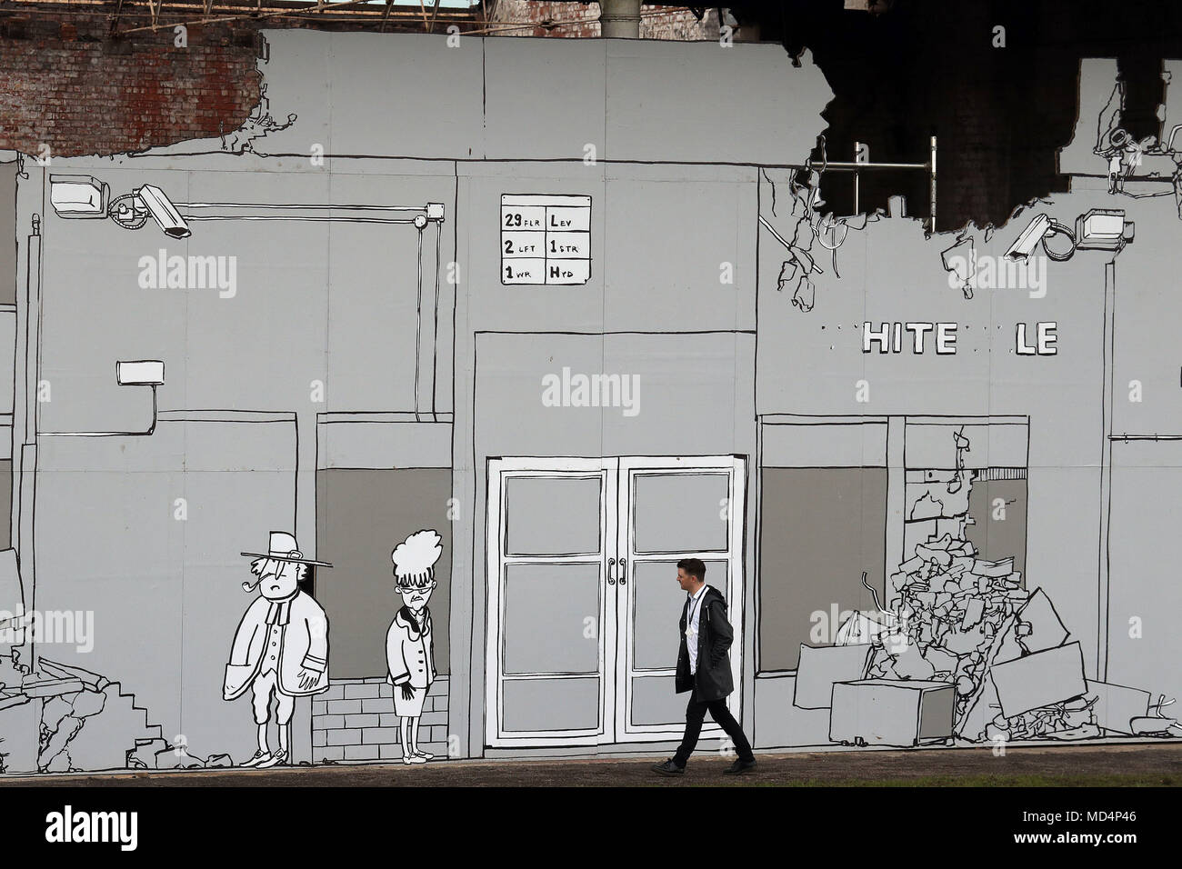 A man Walks Past Regenerators von Mick Peter, einer 80 Meter langen Plakatwand in Glasgow, die die leere Fassade eines historischen, ehemaligen Gasreinigungsschuppens bedeckt, das Teil des Glasgow International Festival of Visual Art ist Stockfoto
