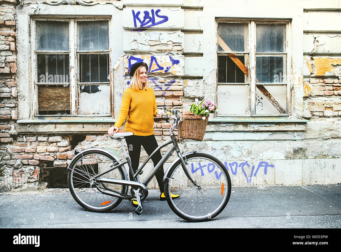 Junge Frau mit dem Fahrrad in den sonnigen Frühling Stadt. Stockfoto