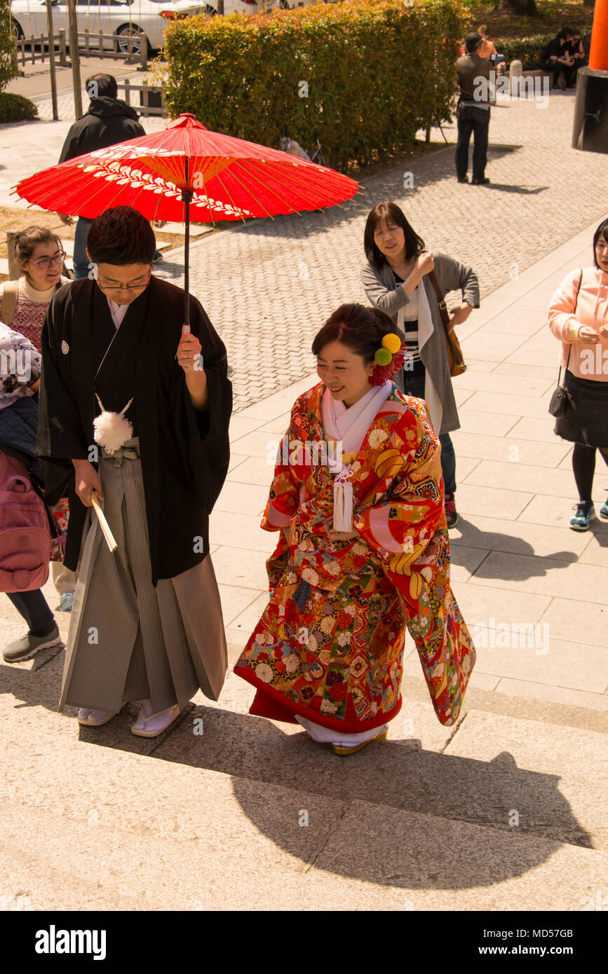 Paar in traditionelle Japanische dress Treppen steigen geschützten zu Heiligtum von Sonnenschirm Stockfoto