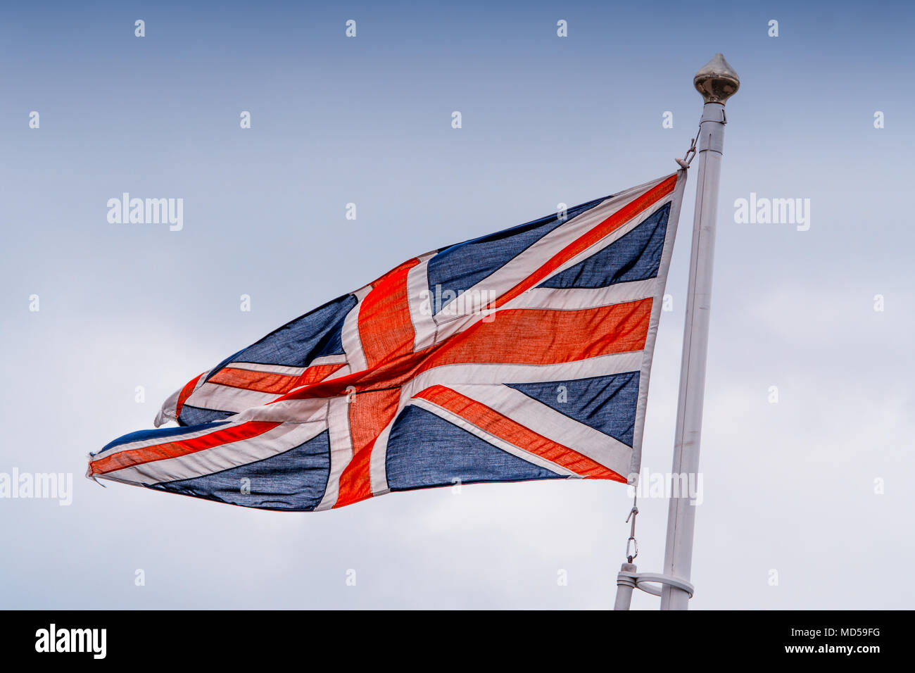 Die Flagge weht im Wind. Vor einem klaren blauen Himmel. Stockfoto