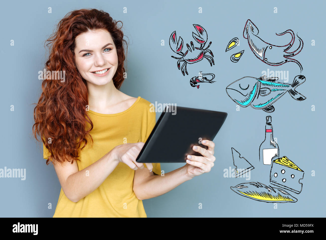Fröhliches essen Blogger lächelnd, während Sie einen Tablet-PC Stockfoto