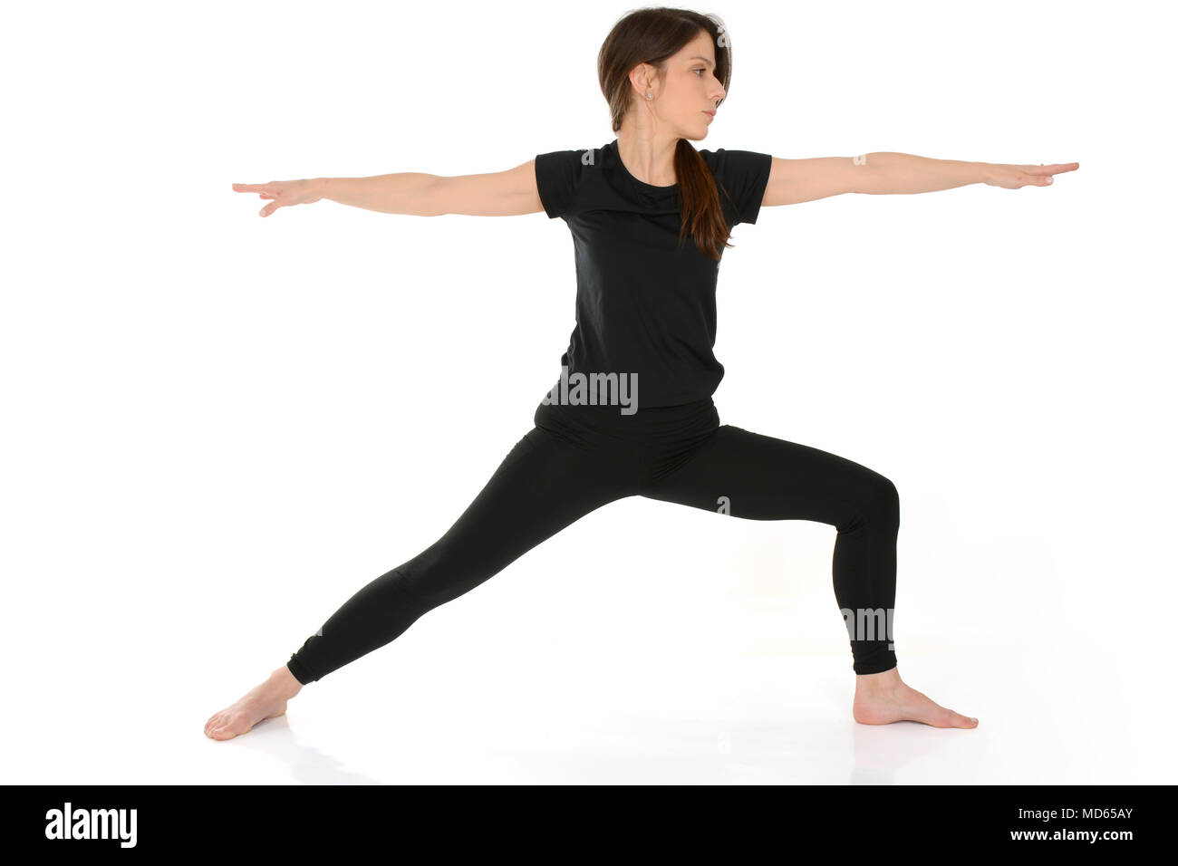 Junge Frau Yoga Asana Virabhadrasana Warrior Pose isoliert auf weißem Hintergrund Stockfoto